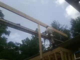 Carpenter setting a ridge beam over a new addition frame — Ice Dam Removal by Roofing Brothers in Cowiche