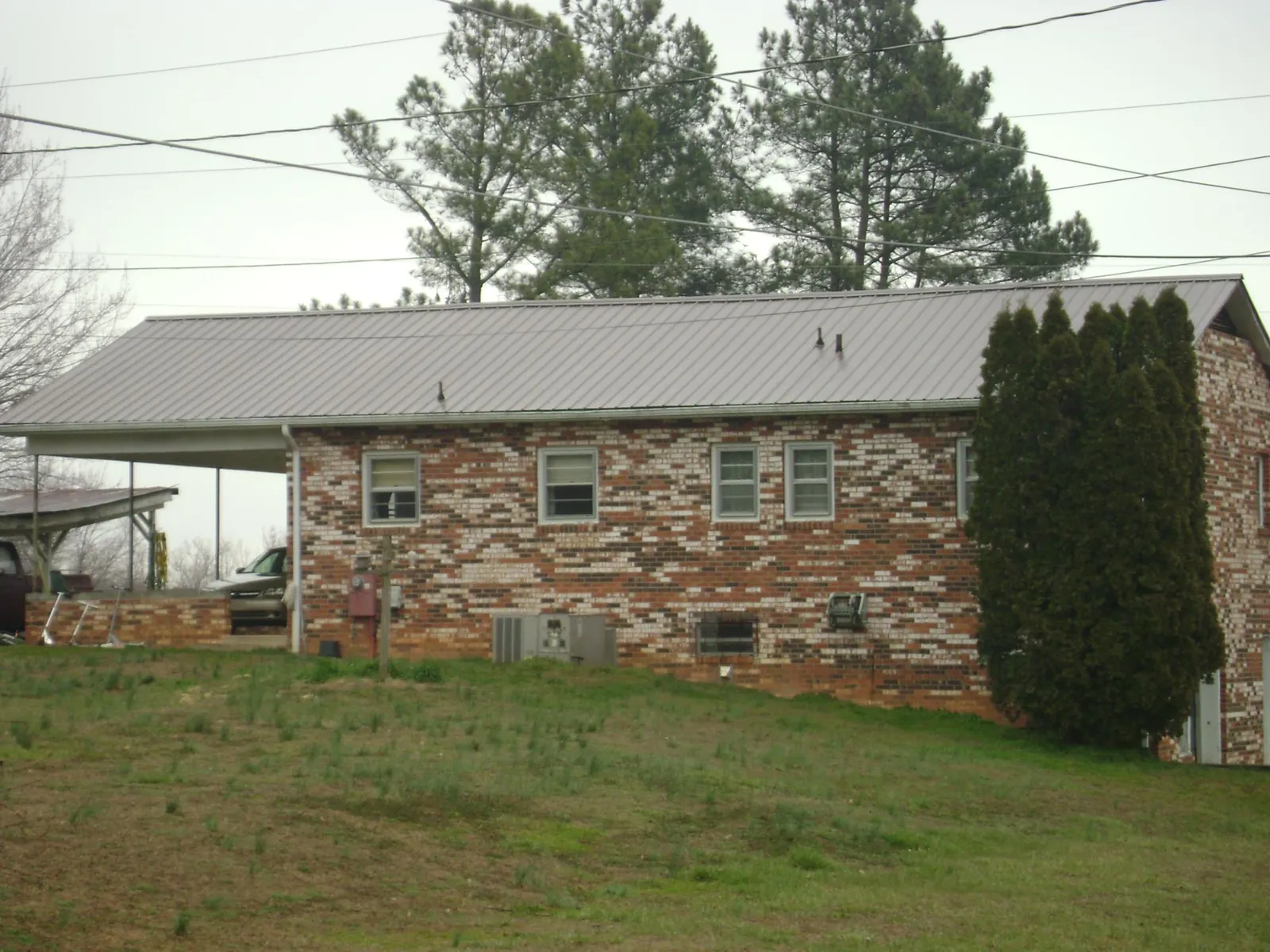 Gray metal roof on a brick split level home with a carport in Cowiche